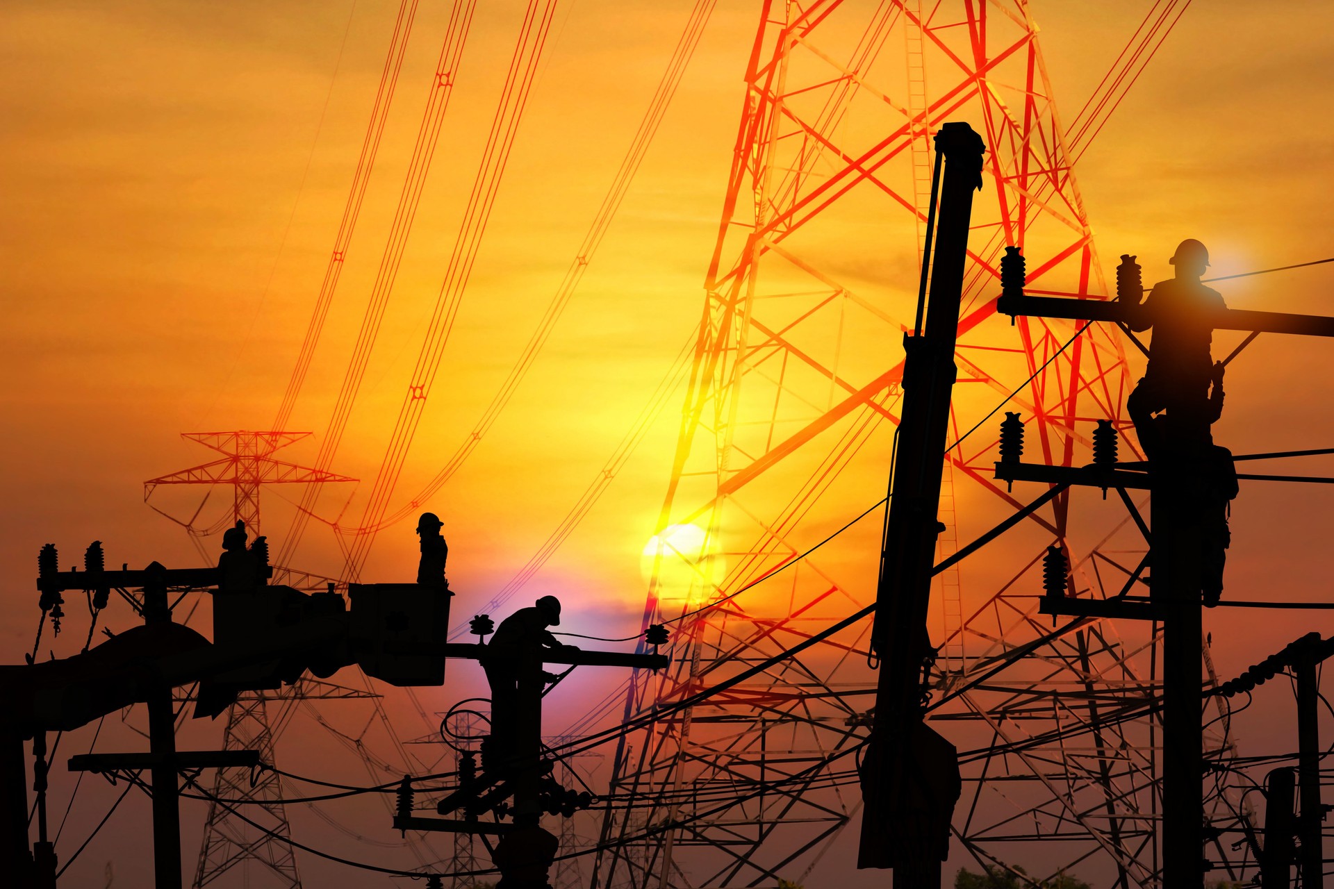 group of silhouette electric worker working on pole connected high voltage transmission line with  high volttag transmission towers