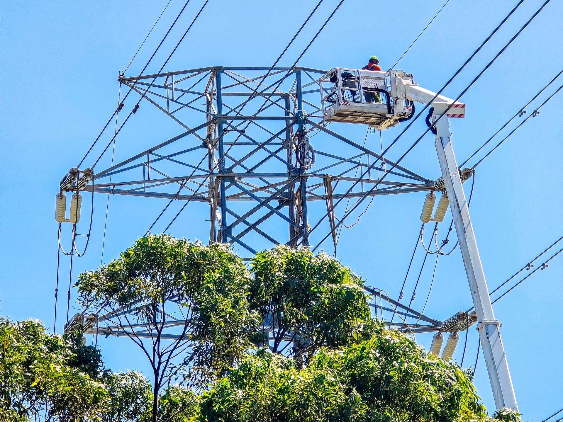Repairing high voltage electricity pylon, background with copy space