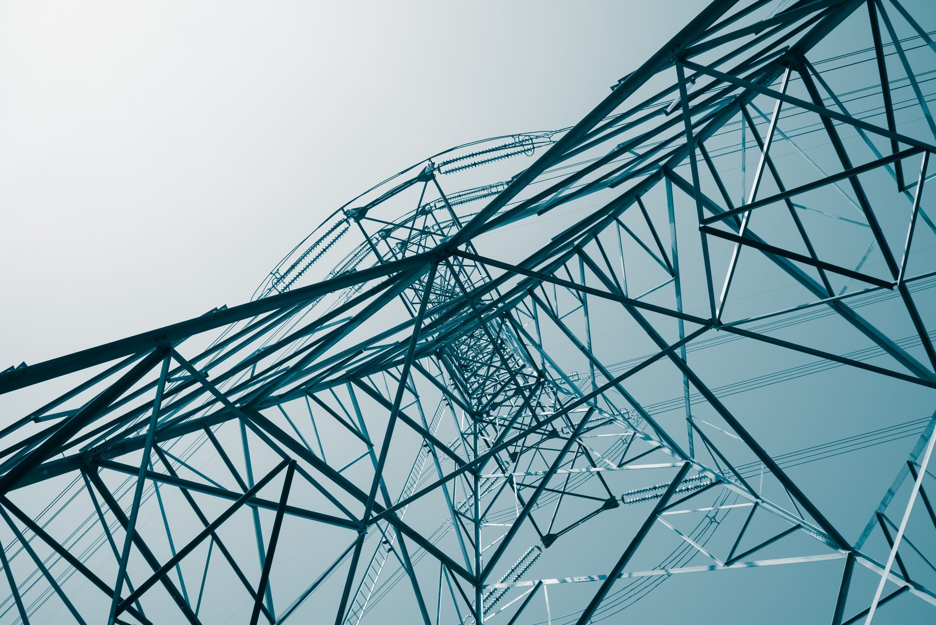 Abstract pattern from bottom view of high voltage pole power transmission tower with clear sky sunny day background.